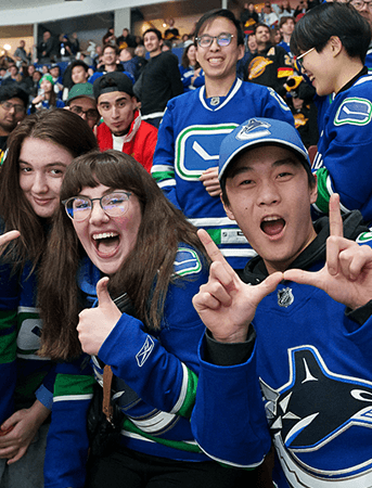 Excited Canucks fans cheering on the team.