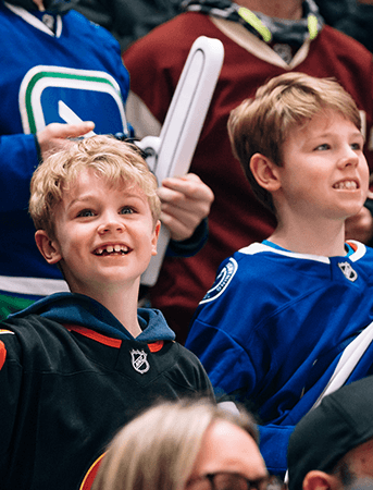 Members of a minor hockey group watch an exciting Vancouver Canucks game.